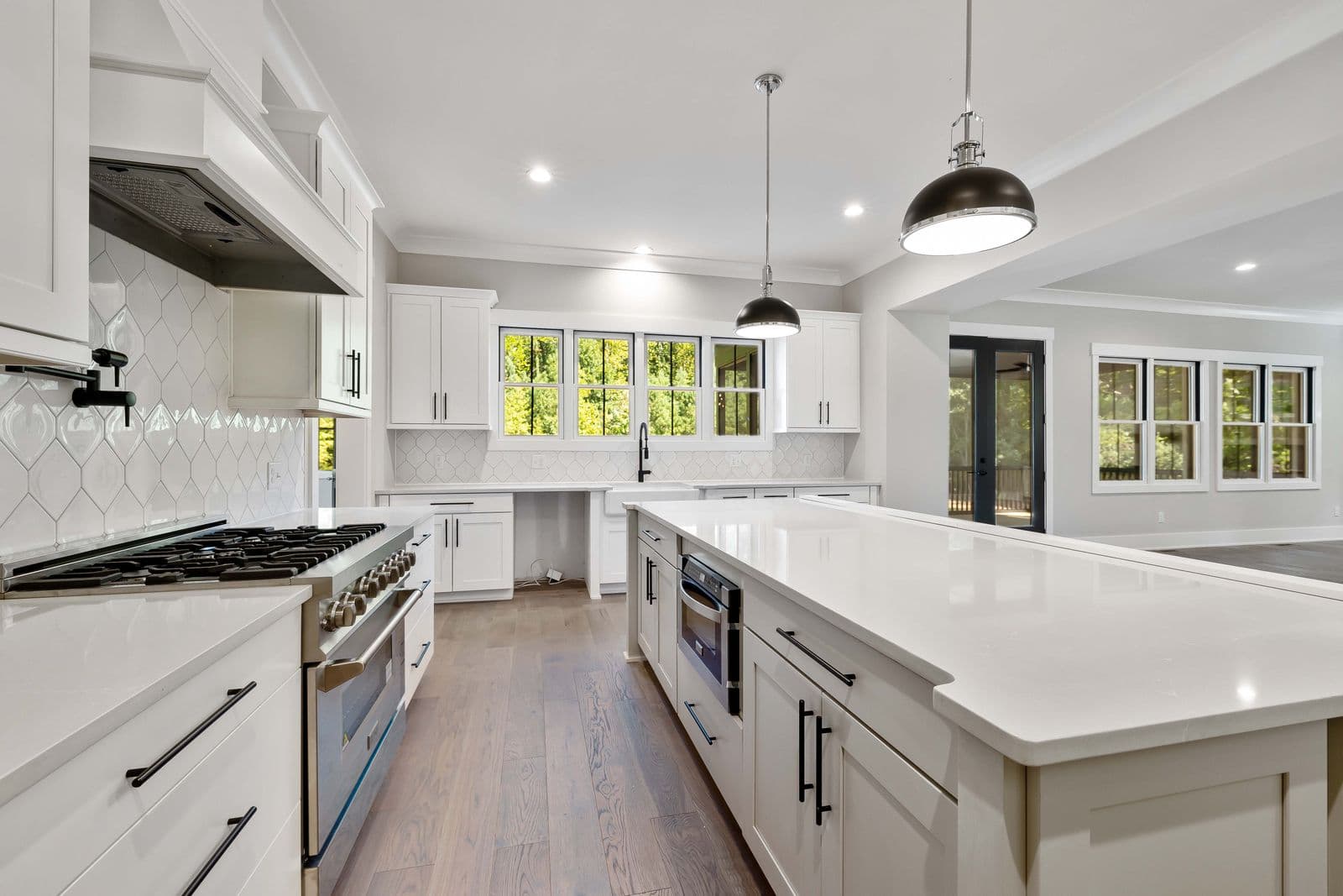 Newly renovated kitchen with new white cabinetry, quartz counters, and fresh tile