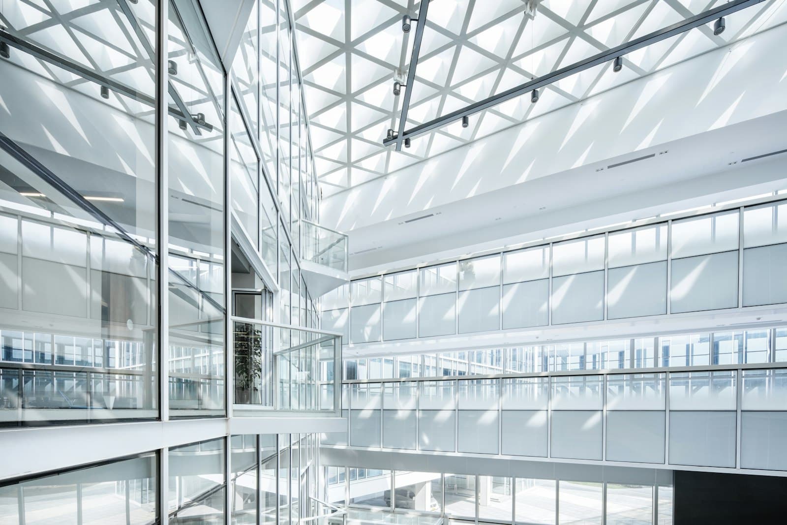 Bright, modern glass office atrium with a geometric skylight and architectural detail